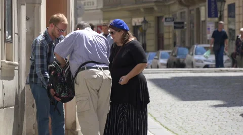 Three people searching in a backpack in Prague Stock Footage 56244760