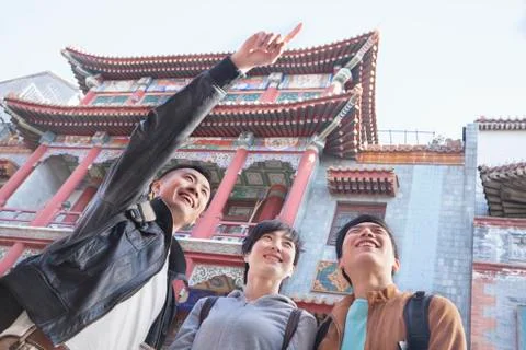 Three people sightseeing, looking and pointing. Stock Photos