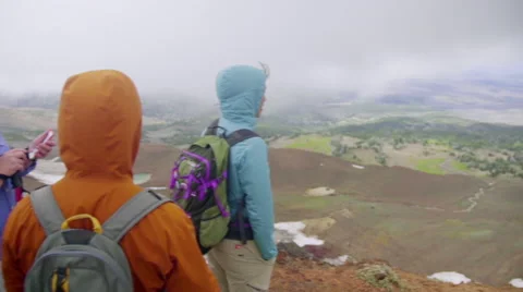 Three people stand at the top of a mountain Stock Footage 59516096