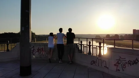 Three people standing on a bridge at sunrise in early morning Dresden, Germany  Stock Footage 106341663