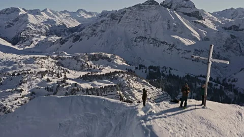 Three people summit ridge mountains austria switzerland alps snow covered drone, Video stock 169055144