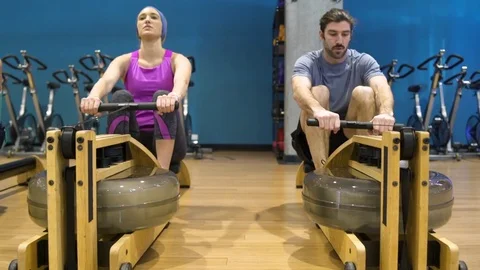 Three people using rowing machines Stock Footage 77082042