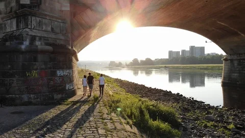 Three people walking underneath a bridge in early morning Dresden sunrise  Video stock 106341412