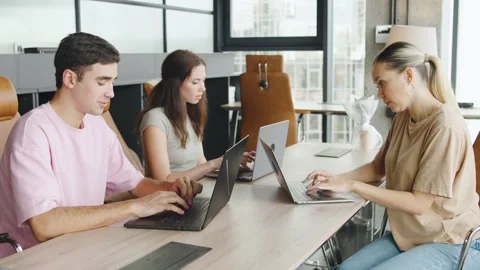 Three people working on laptops in a modern office during the day with natural Video stock 330690394