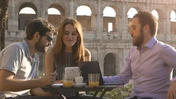 Three people working together on a project with laptop and tablet writing Stock Footage 85594182