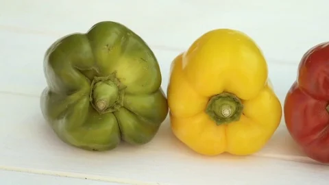 Three peppers, one red, one green and one yellow Stock Footage 78175479