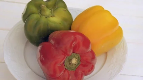 Three peppers, one red, one green and one yellow. Seamless Looping Stock Footage 78175600