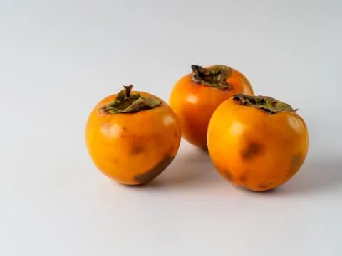 Three persimmon isolated on white background. Stock Photos
