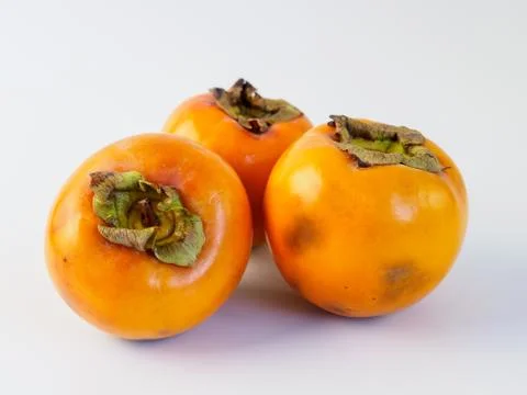 Three persimmon isolated on white background. Stock Photos