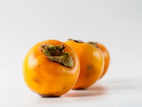 Three persimmon isolated on white background. Stock Photos