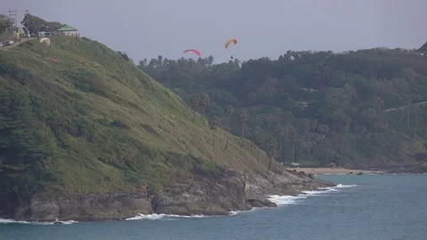 Three persons paragliding near wind mill and one preparing the parachute 4K Vídeos de archivo 71469732