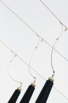 Three-phase electrical lines and ceramic insulators Stock Photos
