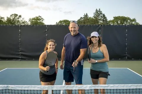Three Pickleball Players Posing at Net Stock Photos