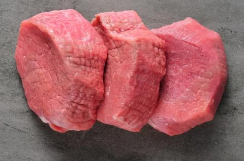 Three piecea of raw beef meat on shale board Foto stock