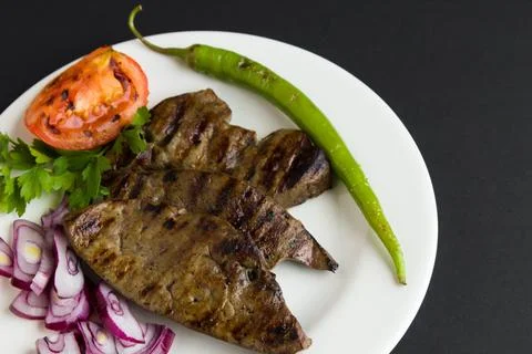 Three pieces of beef liver cooked on the grill Stock Photos