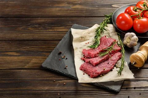 Three pieces of beef on a platter next to the seasoning. Stock Photos