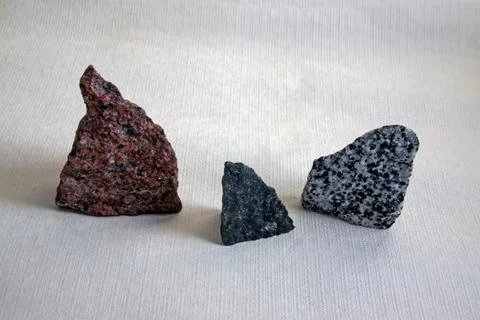 Three pieces of colored granite: red, black, gray Stock Photos