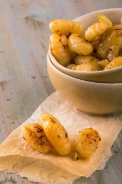Three pieces of gnocchi in front of portion in bowl Stock Photos
