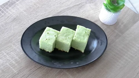 Three pieces of pandan cake arranged on a black plate Stock Footage 236849258