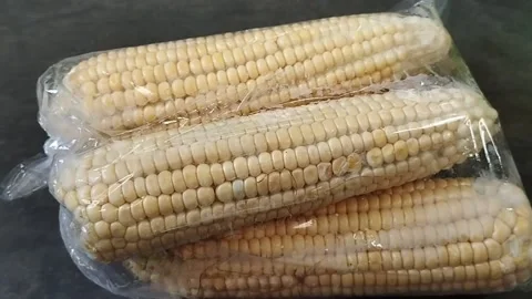 Three pieces of raw corn in plastic Stock Footage 226730431