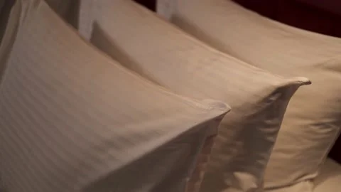 Three pillows lie flat on the bed of the hotel room before check-in Stock Footage 164559226