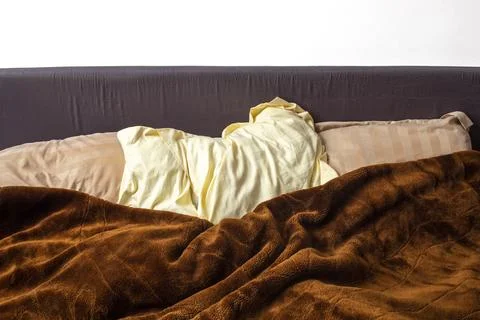 Three pillows under a brown fluffy blanket on a king size bed, sleepin with.. Stock Photos