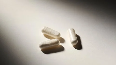 Three Pills or drug rotating on white desk. Stock Footage 101074908
