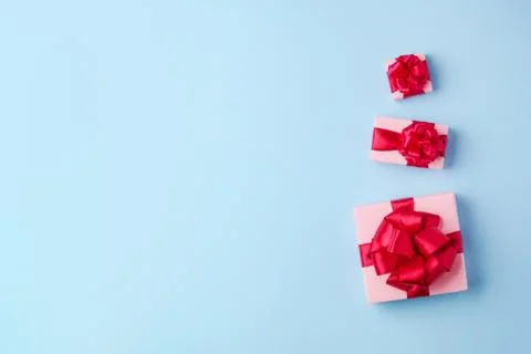 Three pink boxes on a light blue paper background. Stock Photos