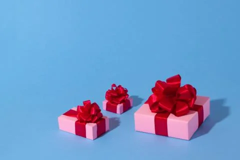 Three pink boxes on a light blue paper background. Foto stock