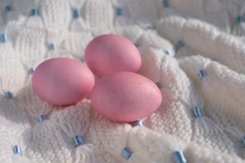 Three pink Easter eggs on a white knitted blanket Stock Photos