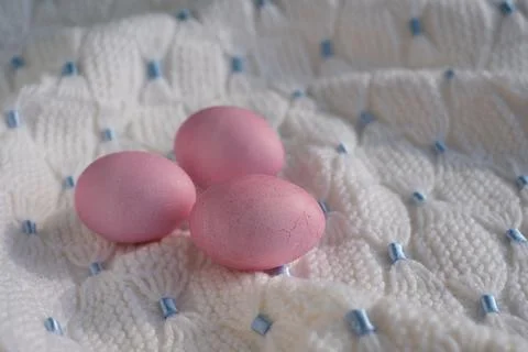 Three pink Easter eggs on a white knitted blanket Stock Photos