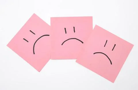 Three pink sticky notes with sad face drawings Stock Photos
