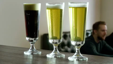 Three pints of beer standing on the bar counter in a modern restaurant. 4K Stock Footage 90969097