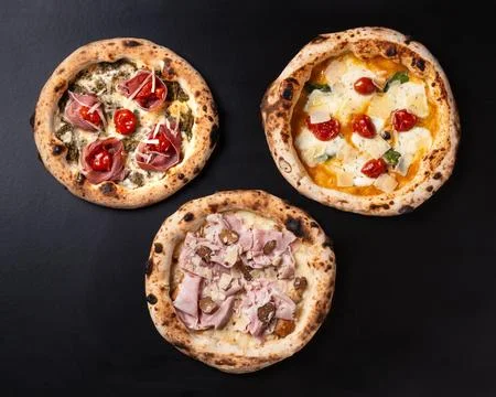 Three pizzas of various flavors Stock Photos