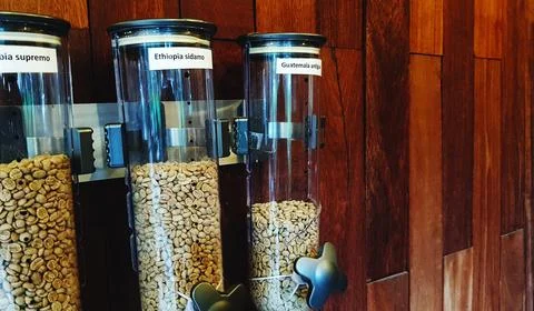 Three plastic bottle of coffee bean or seed jar hanging on brown wooden wall Stock Photos
