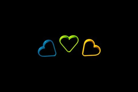 Three plastic cookie cutters, blue, yellow and green, for making cookies in t Stock Photos