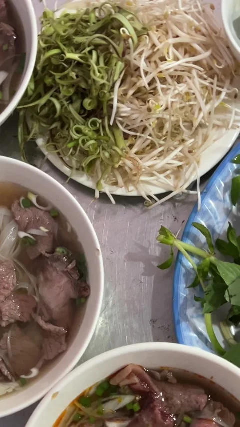 Three plates on the table Soup pho bo serve buy phobo soup Pho Bo vietnamese Stock Footage 310440182