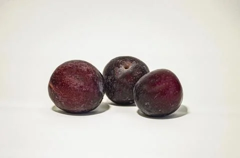 Three plums on a white background Stock Photos
