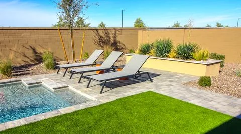 Three Pool Side Lounge Chairs In Rear Yard Stock Photos