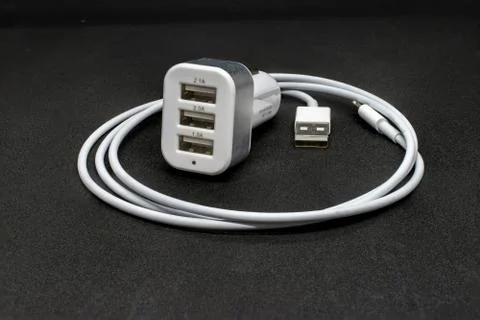Three port USB car cigarette adapter and cable on a dark grey background Stock Photos