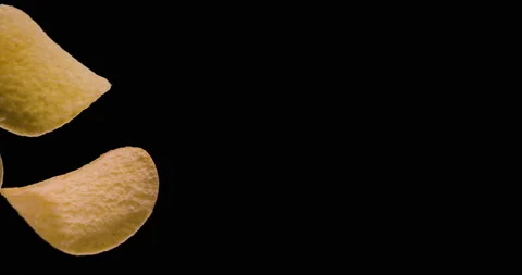 Three potato chips are spinning on a black background. Video stock 159059025