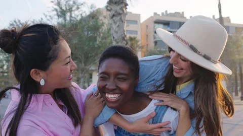 Three pretty smiling friends having fun piggyback together outdoor sunny summer Stock Footage 250863177