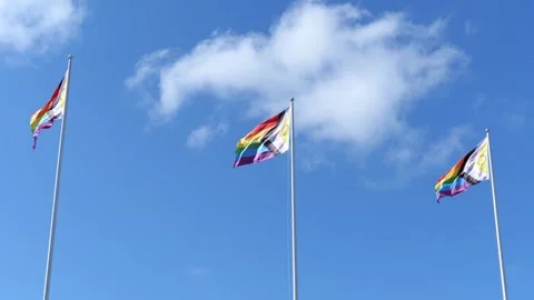 Three Pride Flags Waving on Pole with Blue Sky. Stock Footage 311109613