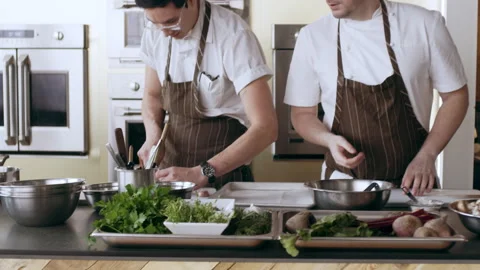 Three professional chefs cooking and preparing food in pots and pans in interior Stock Footage 199461509