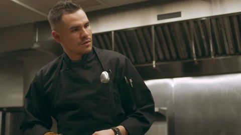 Three professional chefs peeling and cutting vegetables for cooking at a long co Stock Footage 199455350