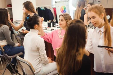 Three professional make-up artists work with beautiful young women. School of Stock Photos