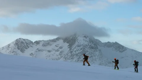 Three professional skiers walking together on snow-covered alps Stock Footage 116786959