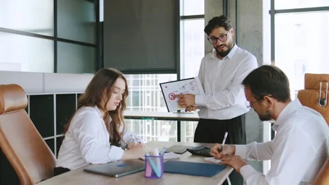 Three professionals in a contemporary office collaborate on project updates Stock Footage 315781121