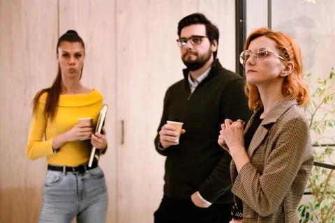 Three professionals engaged in discussion during a casual meeting at a modern 写真素材