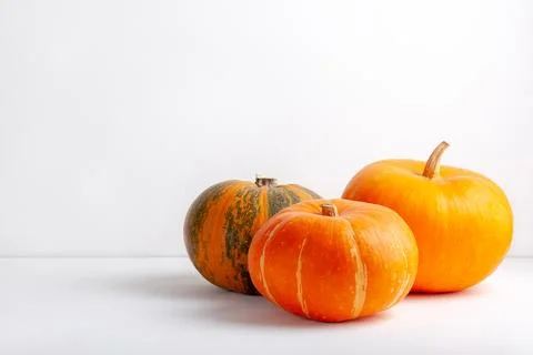 Three pumpkins on a white background. Copy space Stock Photos
